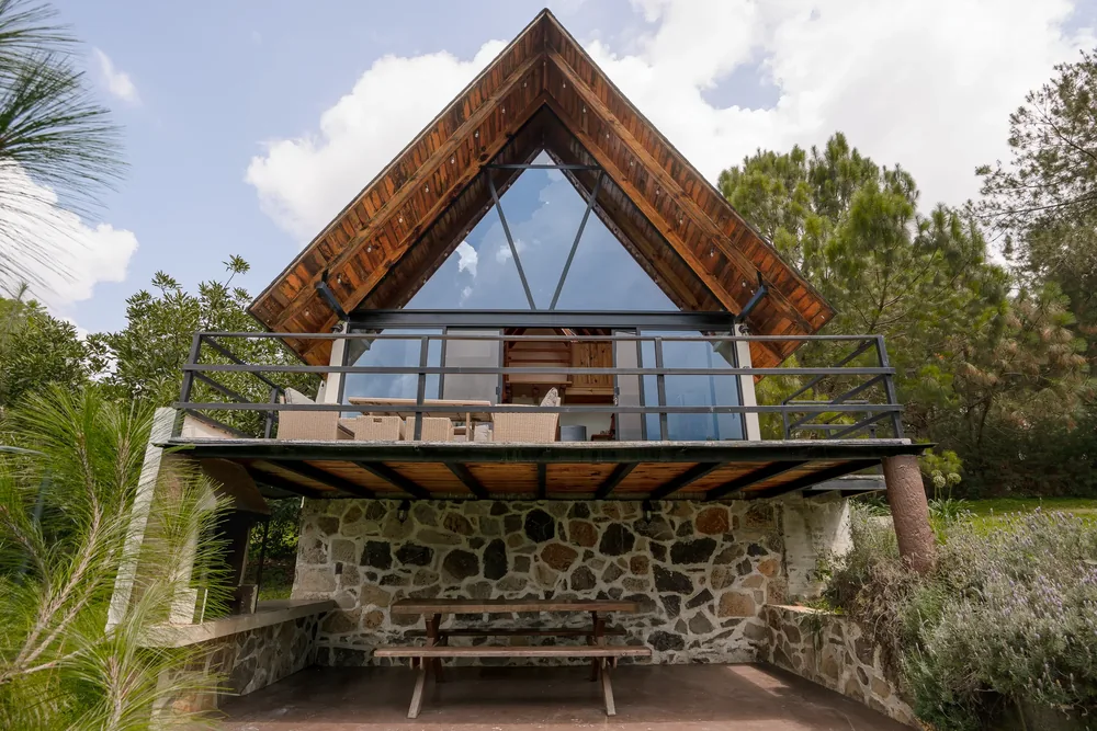 Cabaña Sagitario estilo A-frame con terraza sobre base de piedra