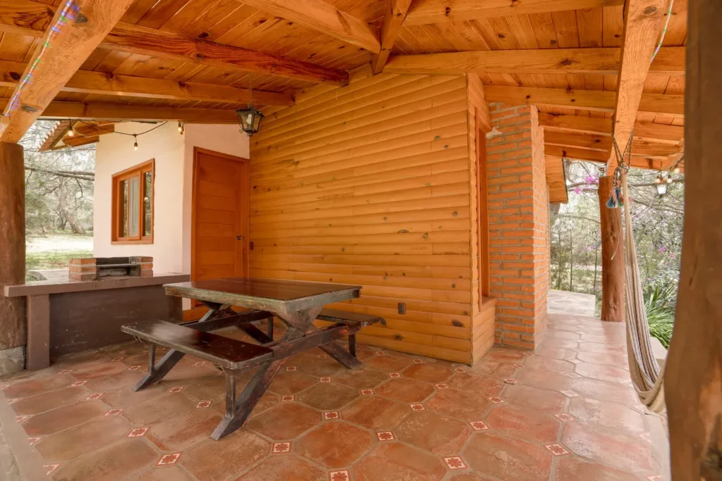 Terraza con asador y mesa de la cabaña Orión